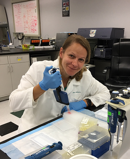 image of a scientist in a lab with equipment in hand